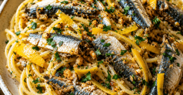 Spaghetti méditerranéens garnis de sardines fraîches dorées, de petits dés de citron confit, de persil et de chapelure croustillante.