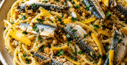 Spaghetti méditerranéens garnis de sardines fraîches dorées, de petits dés de citron confit, de persil et de chapelure croustillante.