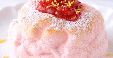 Cloud bread fraise-citron en forme de dôme rose pâle, à la texture aérienne, décoré de fraises fraîches et de fins zestes de citron.
