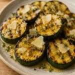 Rondelles épaisses de courgettes grillées et dorées, nappées de miel brillant, parsemées de thym frais et garnies de copeaux de parmesan.