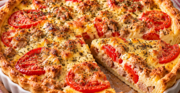 Tarte au thon et tomates bien dorée, garnie de moutarde, crème, fromage râpé et herbes de Provence.